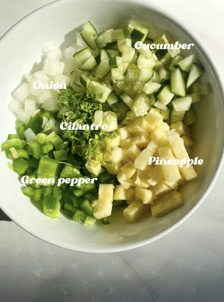 bowl of pineapple salsa with cucumbers, pineapple, green bell peppers, onion, and cilantro.  